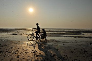 Fototapeta premium man riding a bike on the beach