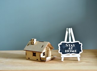 Social media awareness campaign and coronavirus prevention concept with word on blackboard "STAY AT HOME" isolated on gray background.