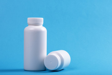 two white medical container bottles on blue background
