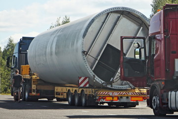 Big large pipe on a low-frame trawl semi truck,oversized cargo transportation on long vehicle