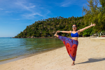 Asian Thai woman practicing yoga in Haad Salad beach, Koh Phangan island, Thailand