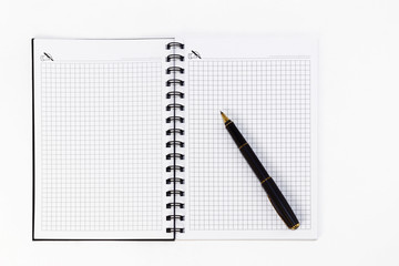 Empty stylish spiral Notepad for notes and a beautiful corporate pen on a white background. Empty space. Stylized stock photos. The view from the top.