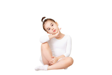 Beautiful little girl sits beautifully in a white dance swimsuit