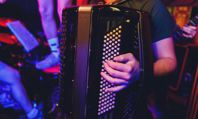 The musician plays the accordion close-up club.