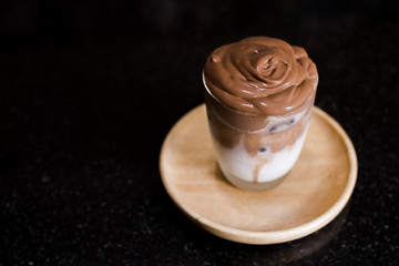 Iced Dalgona Cocoa / Chocolate, a creamy whipped cocoa on fresh milk, on black background