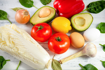 tomato, lemon, spinach, avocado, pepper, garlic, onion, lettuce, fresh vegetables and herbs on a white