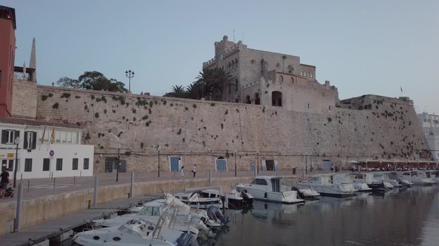 Rear view of woman in red dress and long hair taking mobile photo view to Cathedral Basilica of Ciutadella de Menorca, Spain.