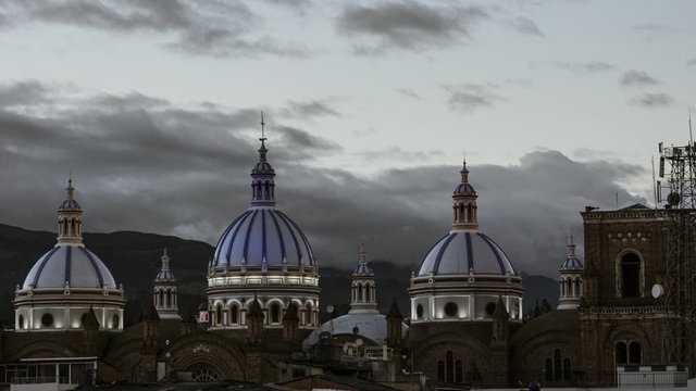 The domes of the New Cathedral in Cuenca, Ecuador light up at sunset in the colors of the Ecuadorian Flag.