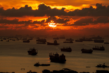 Silhouette image of large number of  tankers and container ships at Singapore strait in the morning.