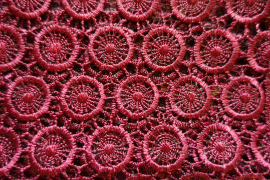 Vibrant red crochet lace fabric from above