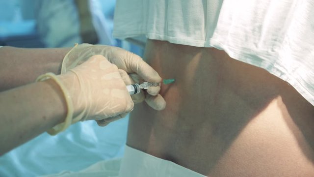 Doctor is injecting a female patient into her back