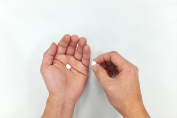Half medicine pill on hand palm. Decrease dosage due to high price 