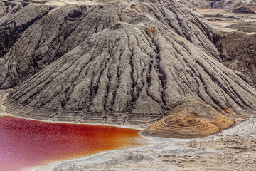Amazing  apocalyptic landscape like a planet Mars surface. Solidified red-brown black Earth surface. Barren, cracked and scorched land. Global warming concept. Refractory clay quarries.
