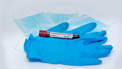 Obraz premium Medical gloves and protective masks with a blood sample on a white background. Outbreak of the coronavirus concept COVID-19. Coronavirus - 2019-nKoV. Stay at home while in quarantine.
