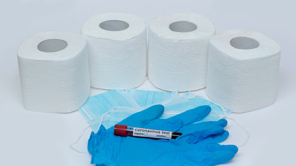 Rolls of toilet paper with medical gloves and protective masks on a white background. Outbreak of the coronavirus concept COVID-19. Coronavirus - 2019-nKoV. Stay at home while in quarantine.
