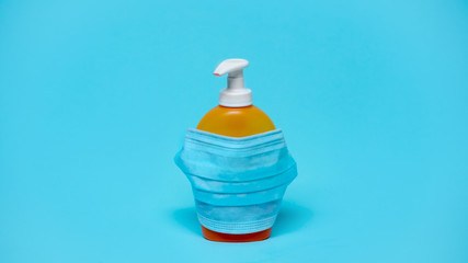 A bottle with an antiseptic, detergent, soap on a blue background. Hand disinfection. Disease Prevention Stay at home while in quarantine. coronavirus protection. Close-up.