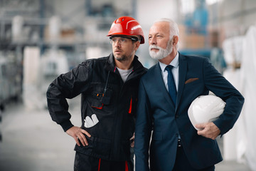 Colleagues working together. Arhitect and worker in factory.