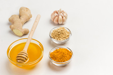 Ginger root, dry ginger and turmeric powder, garlic and lemon on white background