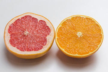 Half grapefruit and half  orange, Close up. White background. Top view.