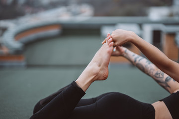 Fototapeta premium Woman practicing yoga on the roof and doing yoga exercises