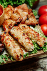  Restaurant dish with vegetable decor on a wooden background. Set of skewers with greens on a wooden Board.