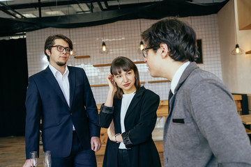 Group of business people in a meeting standing grouped in a office