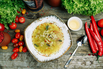 Azerbaijani restaurant dish with vegetable decor on a wooden background. Yellow soup dushbara in the plate of dumplings.
