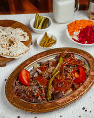 a platter of beef kebab topped with tomato sauce