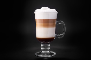 Latte in a glass cup on a black background