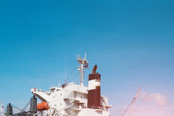 Shipyard with navigation bridge deck with boat exhaust chimney, Ship repair Big Cargo ship at floating dock in shipyard industry with communication antenna and exhaust gas pipe. © TawanSaklay