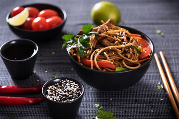 Japanese dish buckwheat noodles soba with chicken and vegetables carrots, bell peppers, mushrooms, green onions