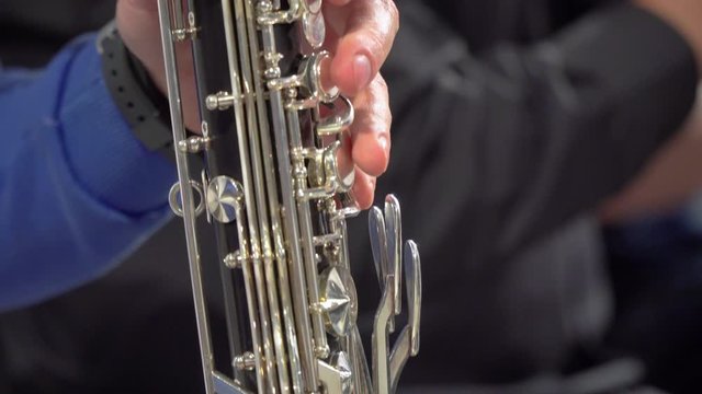 Close up of a man's hands playing saxophone in an orchestra