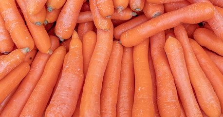 organic carrots top view close up, natural orange background