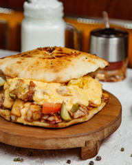 close up of chicken doner with melted cheese pickled cucumber tomato