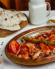 close up of chicken kebab topped with tomato sauce