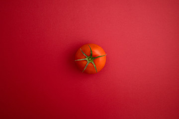 Top view of tomato on red background