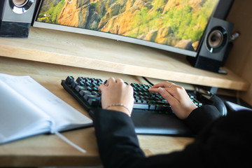young woman writing on keyboard. young woman working from home. woman learns online. online school for students