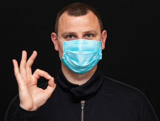 a man puts on a medical mask on his face, instructions on how to wear a mask