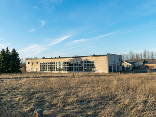 Fototapeta na wymiar Abandoned building in an overgrown field