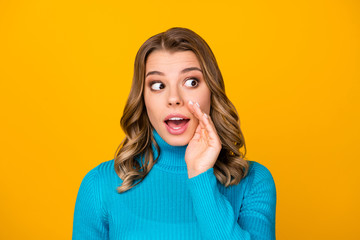 Closeup photo of attractive funny curly lady look side empty space sly person arm near mouth chatterbox wear casual blue warm turtleneck isolated vibrant yellow color background
