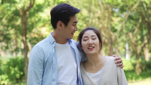 loving young asian couple taking a walk outdoors in park	