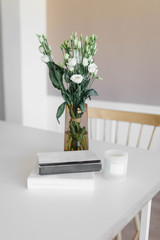 beautiful bouquet of flowers on a white table with two books