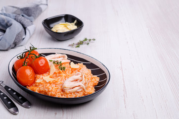 Red rice with seafood tentacles and tomatoes