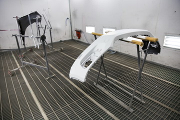 car body part in spray booth  prepared for painting