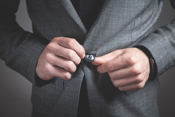 Man fastening buttons on suit.