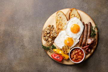 English breakfast on cutting board. Bacon, Bean Tomato Sauce, Grilled Tomatoes, Champignon Mushrooms and Fried Eggs