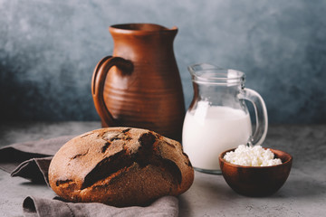 Farm dairy products and bread on gray background