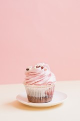 Delicious cupcake with pink strawberry butter cream. Yummy dessert on a table