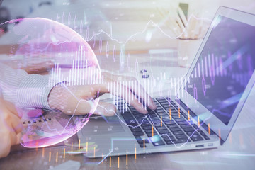 Double exposure of stock market graph with man working on laptop on background. Concept of financial analysis.