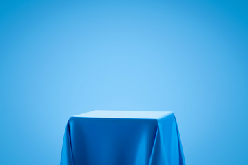 Blue fabric on podium shelf or empty studio display on light blue gradient background with art...